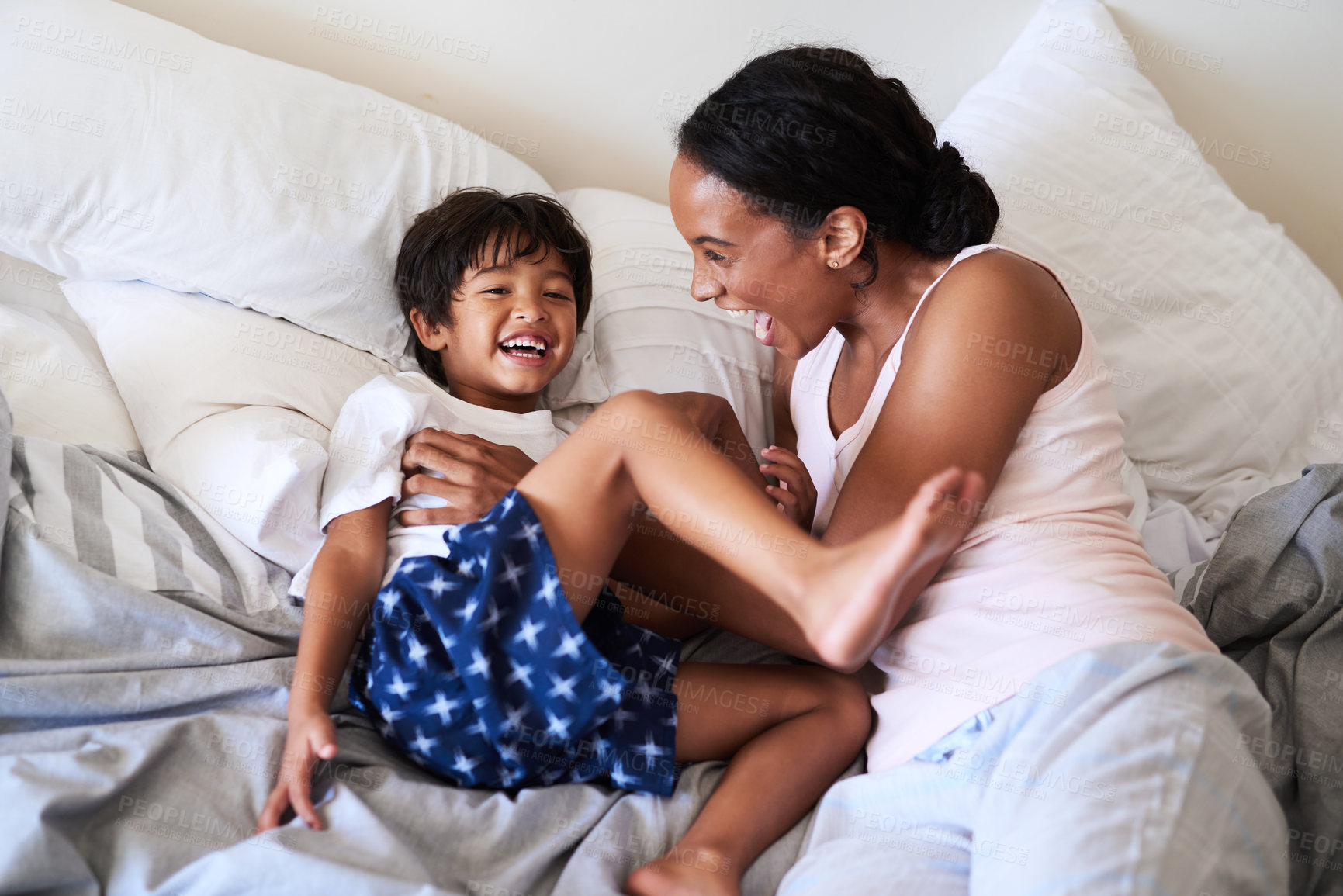 Buy stock photo Happy mother, bed and playing with child for bonding, morning or holiday together at home. Mom, young son or little boy with smile in bedroom pyjamas for playful day, weekend or childhood at house