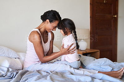 Buy stock photo Shot of a beautiful young mother bonding with her little girl in bed at home