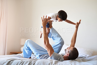 Buy stock photo Shot of a cheerful father and son playing together in the bedroom at home