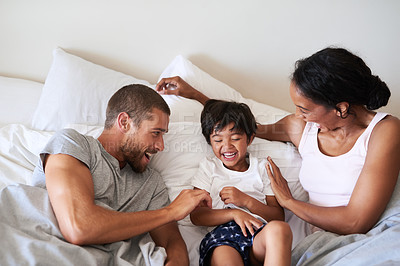 Buy stock photo Shot of a beautiful young family of three spending time together in their bedroom at home