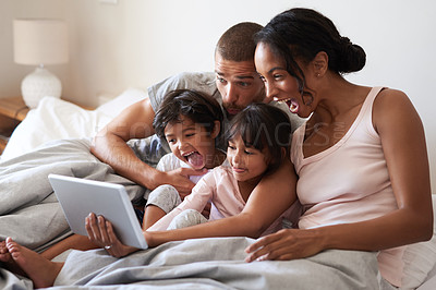 Buy stock photo Shot of a beautiful young family of four taking selfies with a digital tablet in their bedroom