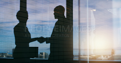 Buy stock photo Silhouette shot of two businesspeople shaking hands inside an office building