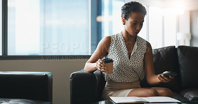 Buy stock photo Shot of a businesswoman using her cellphone while sitting in a modern office