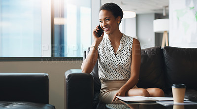 Buy stock photo Shot of a businesswoman talking on her cellphone while sitting in a modern office
