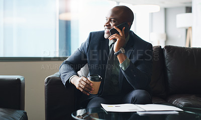 Buy stock photo Shot of a businessman talking on his cellphone while sitting in a modern office