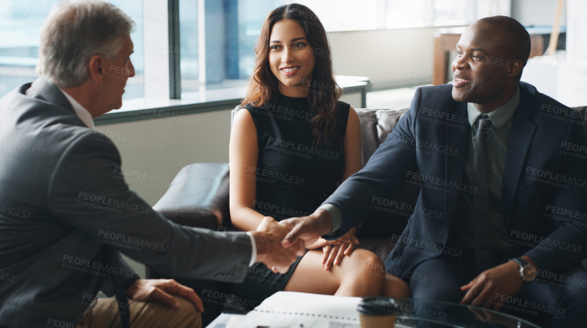 Buy stock photo Shot of a group of businesspeople having a discussion while sitting together on a couch at the office