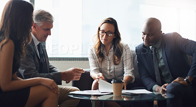 Buy stock photo Shot of a group of businesspeople having a discussion while sitting together on a couch at the office