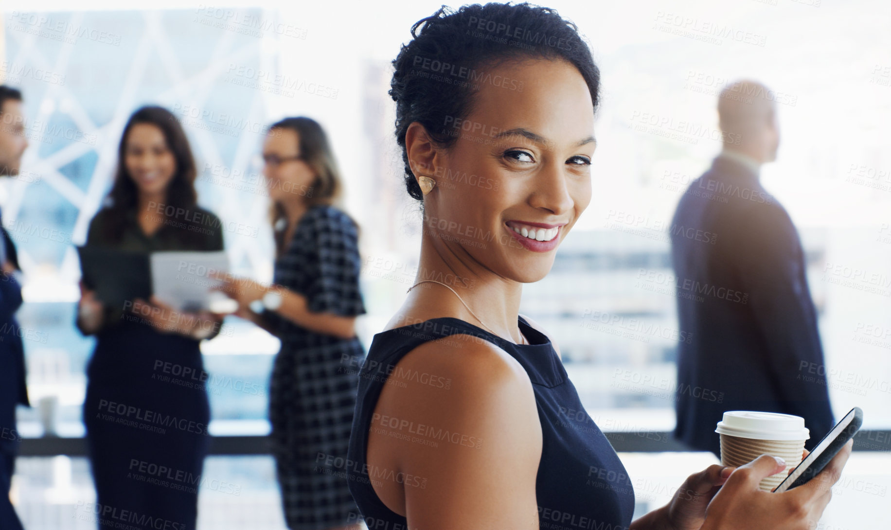 Buy stock photo Shot of an attractive businesswoman smiling at the camera while colleagues are blurred in background