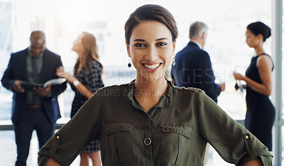 Buy stock photo Shot of an attractive businesswoman smiling at the camera while colleagues are blurred in background