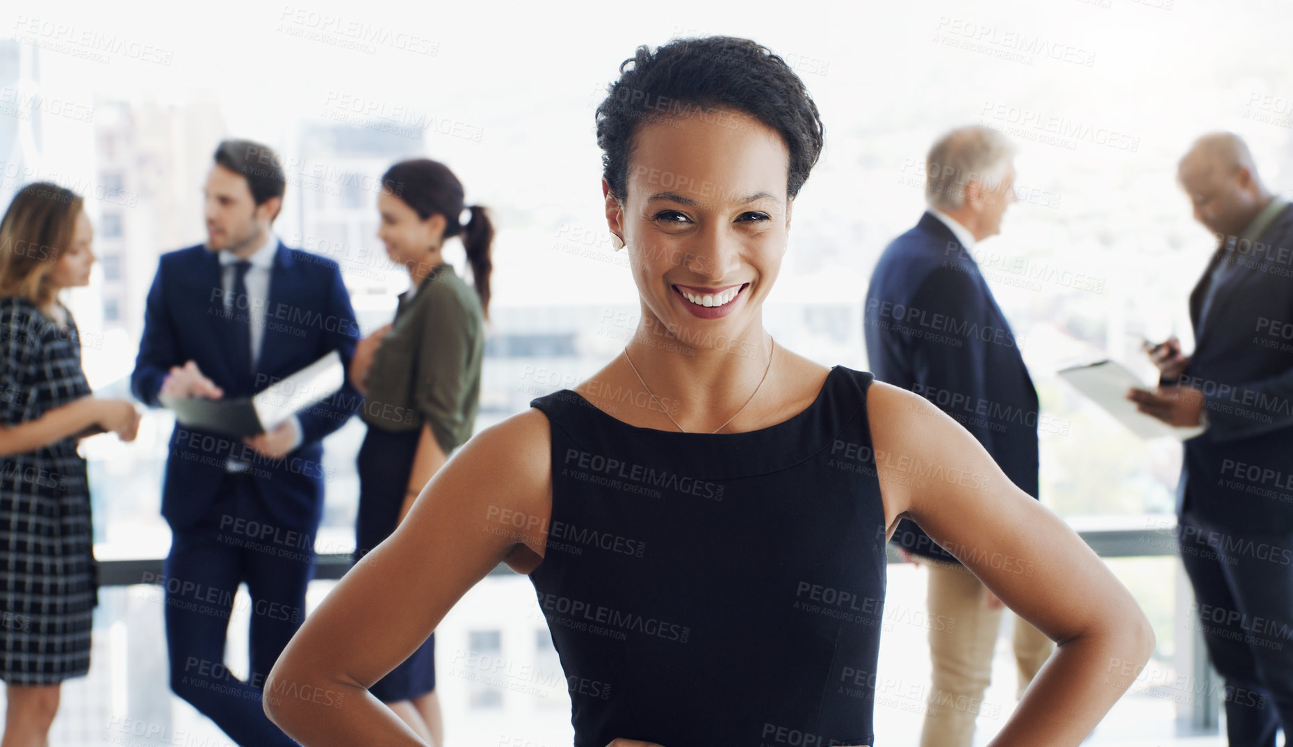 Buy stock photo Shot of an attractive businesswoman smiling at the camera while colleagues are blurred in background