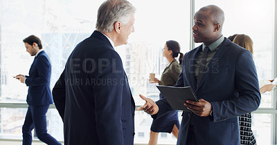Buy stock photo Cropped shot of two businesspeople having a discussion while colleagues are blurred in the background