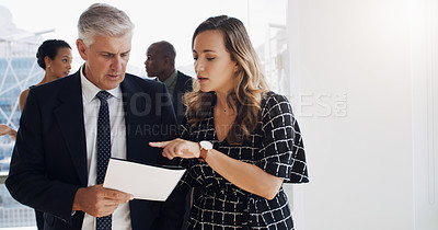 Buy stock photo Shot of two businesspeople discussing something while walking together