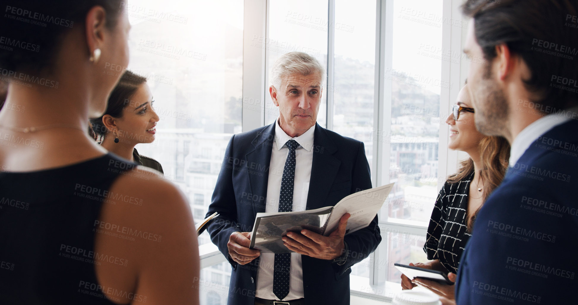 Buy stock photo Shot of a businessman having a meeting with his coworkers