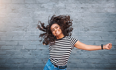 Buy stock photo Portrait of a young woman dancing against a grey wall