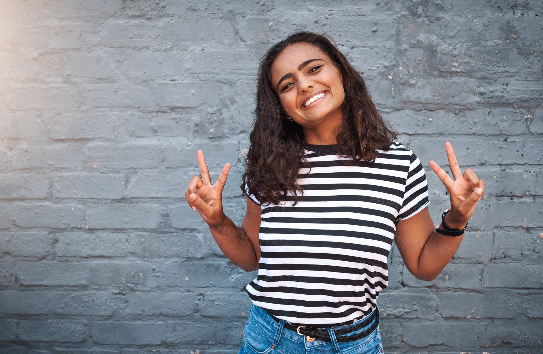 Buy stock photo Brick, wall and peace sign for girl, smile and hands for gesture, outdoor and break for weekend. Proud, excited and student on holiday, morning and happiness on face, model and city of New York