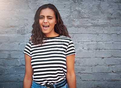 Buy stock photo Brick, wall and girl with wink, happy and student in university with scholarship, goal and education. Outdoor, campus and college of Germany, smile and academy for learning and portrait of person