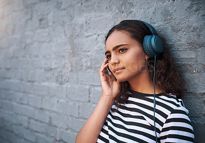 Buy stock photo City, thinking and girl with headphones, streaming music and smile on grey wall with mindset and calm thought. Gen z, outdoor and headset for radio, listening to audio and sound with peace and relax