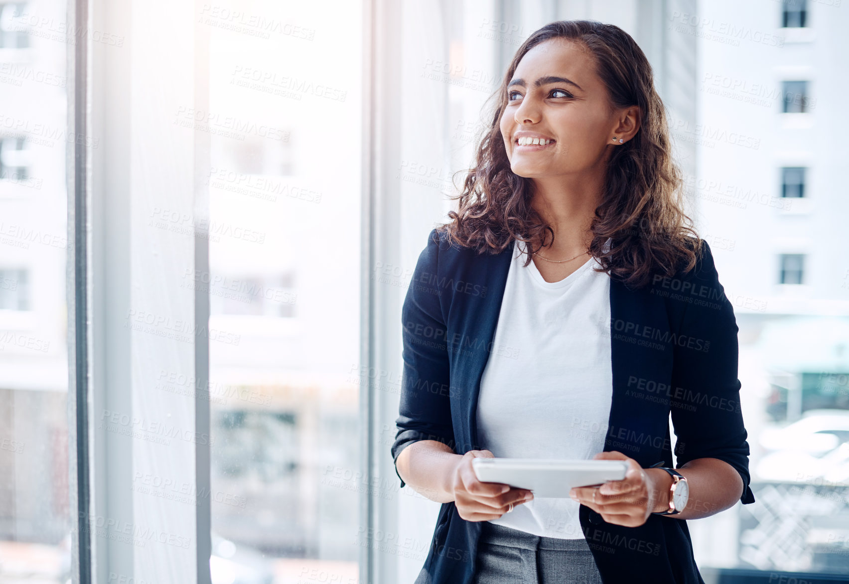 Buy stock photo Shot of a young businesswoman using a digital tablet in an office