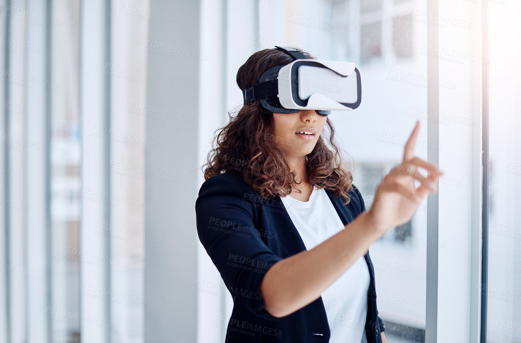 Buy stock photo Shot of a young businesswoman wearing a VR headset in an office