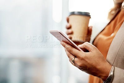 Buy stock photo Shot of an unrecognizable businesswoman drinking coffee and using a cellphone in her office