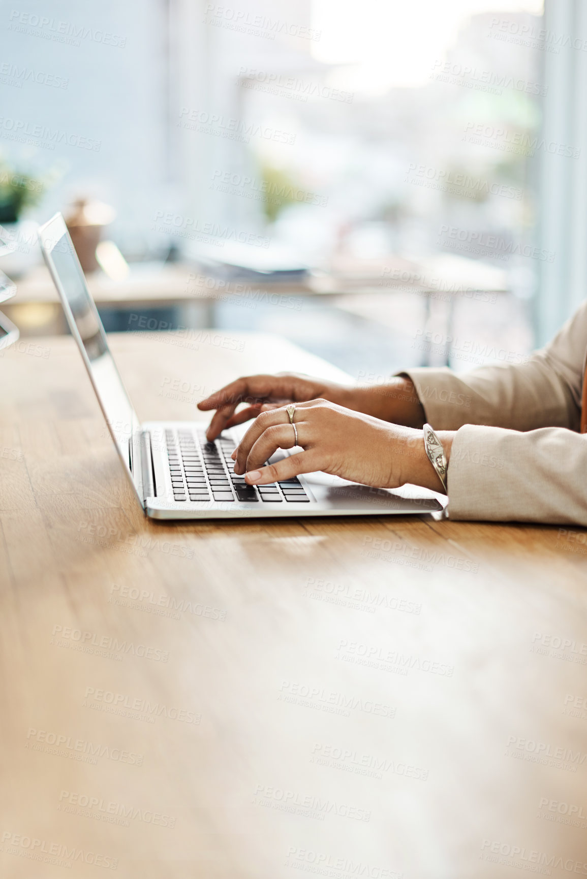 Buy stock photo Shot of an unrecognizable businesswoman working on a laptop on her office