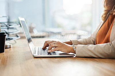 Buy stock photo Shot of an unrecognizable businesswoman working on a laptop on her office