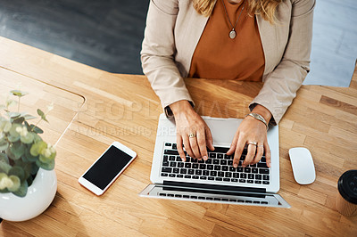 Buy stock photo Shot of an unrecognizable businesswoman working on a laptop on her office