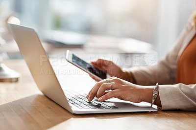 Buy stock photo Shot of an unrecognizable businesswoman using a cellphone and laptop in her office