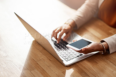 Buy stock photo Shot of an unrecognizable businesswoman using a cellphone and laptop in her office