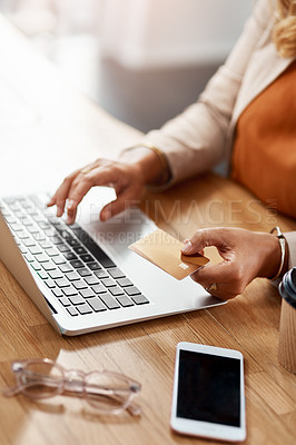 Buy stock photo Shot of an unrecognizable businesswoman using a laptop and credit card to purchase online in her office