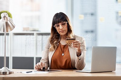 Buy stock photo Shot of a beautiful young businesswoman using a digital tablet and credit card to shop online in her office