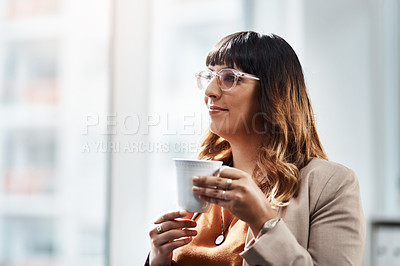 Buy stock photo Shot of an attractive young businesswoman drinking coffee in her office