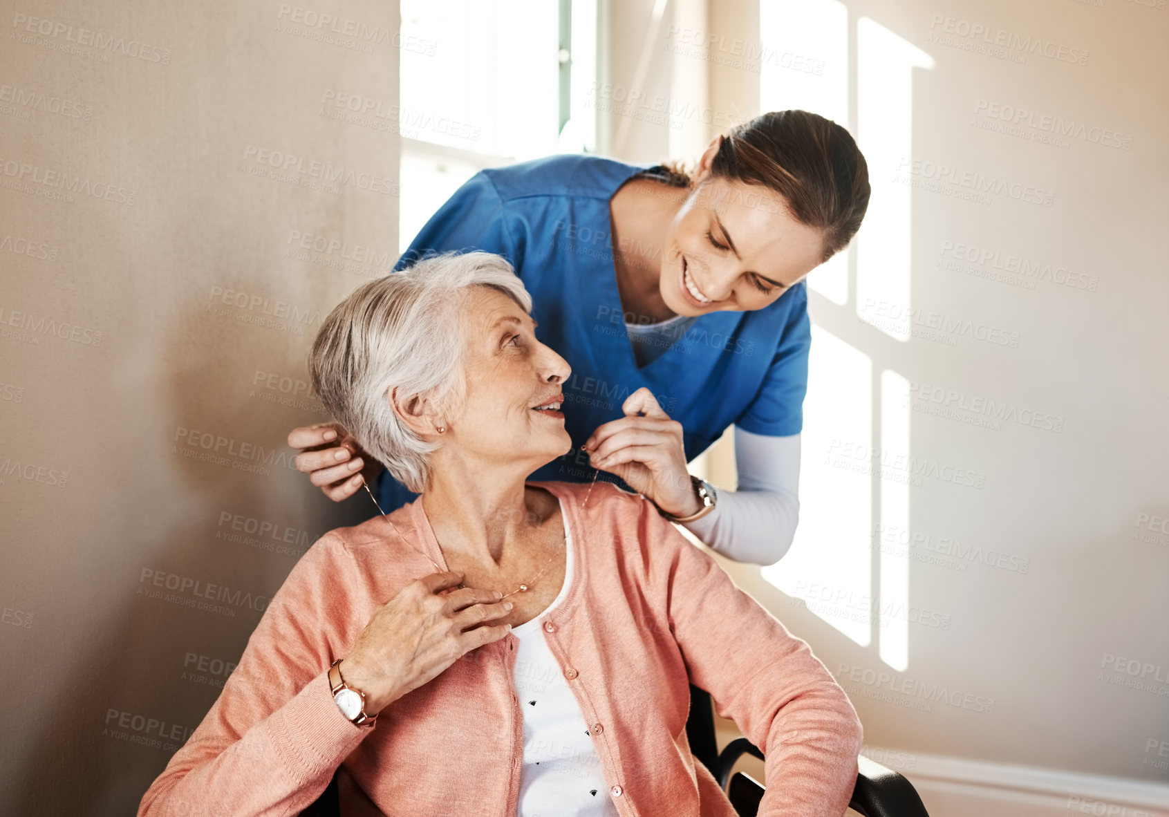 Buy stock photo Shot of a senior woman in a wheelchair being cared for a nurse