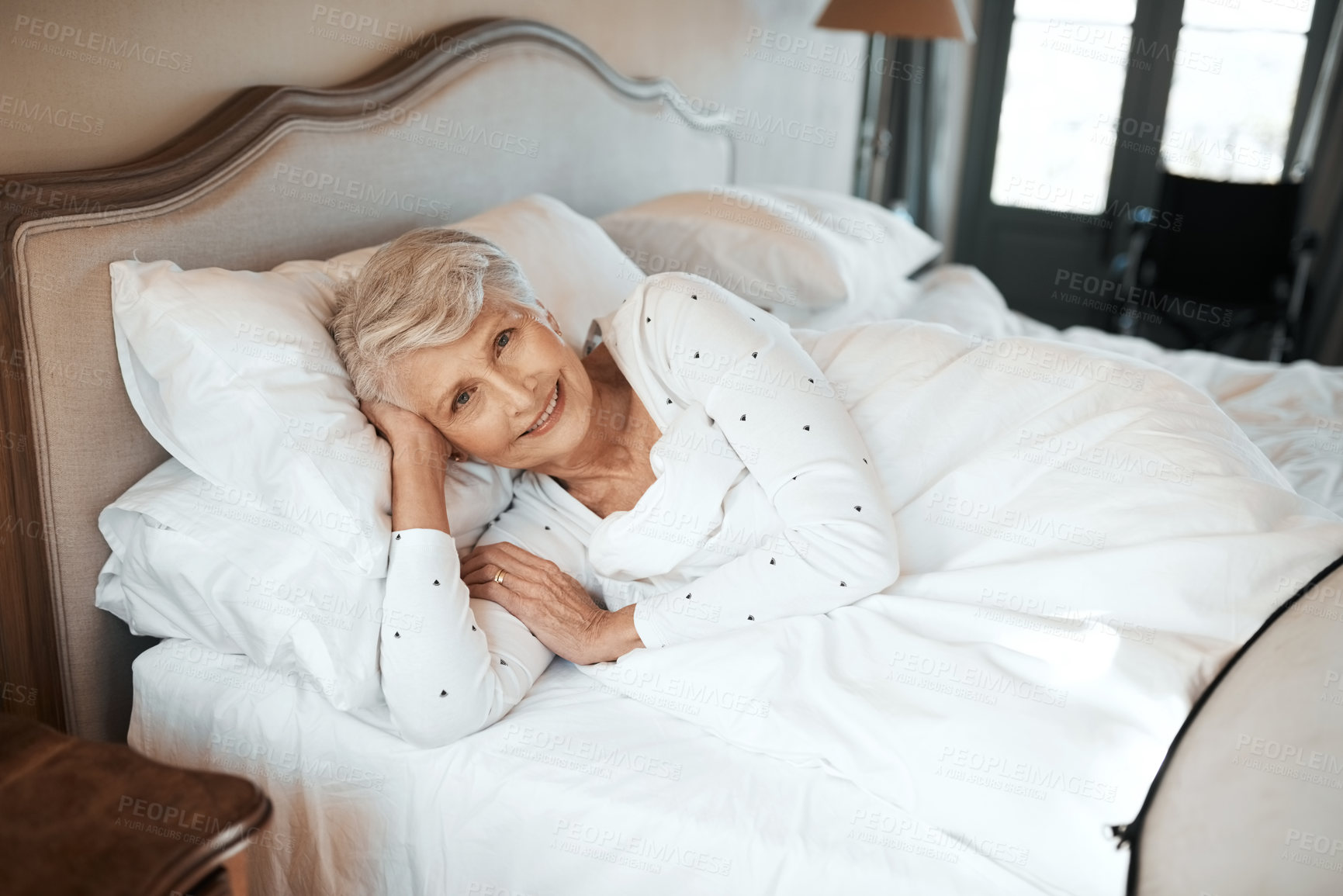 Buy stock photo Shot of a senior woman relaxing in bed in a nursing home