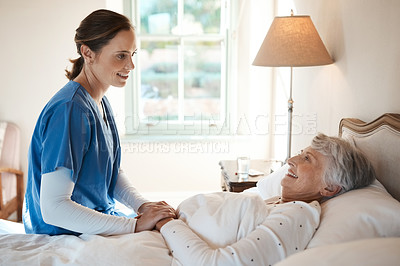 Buy stock photo Shot of a young nurse chatting with a senior woman in bed at a retirement home