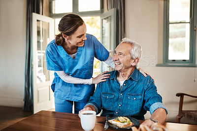 Buy stock photo Shot of a young nurse checking up on a senior man during breakfast at a nursing home