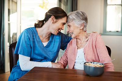 Buy stock photo Shot of a young nurse sitting with a senior woman at breakfast time in a nursing home