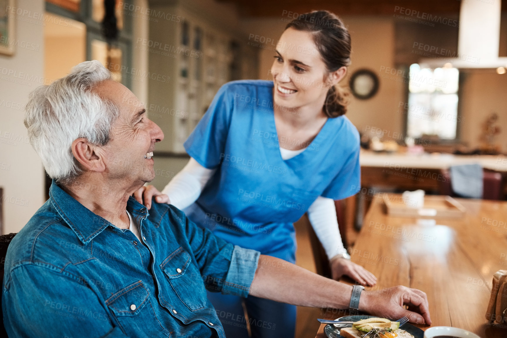 Buy stock photo Shot of a young nurse checking up on a senior man during breakfast at a nursing home