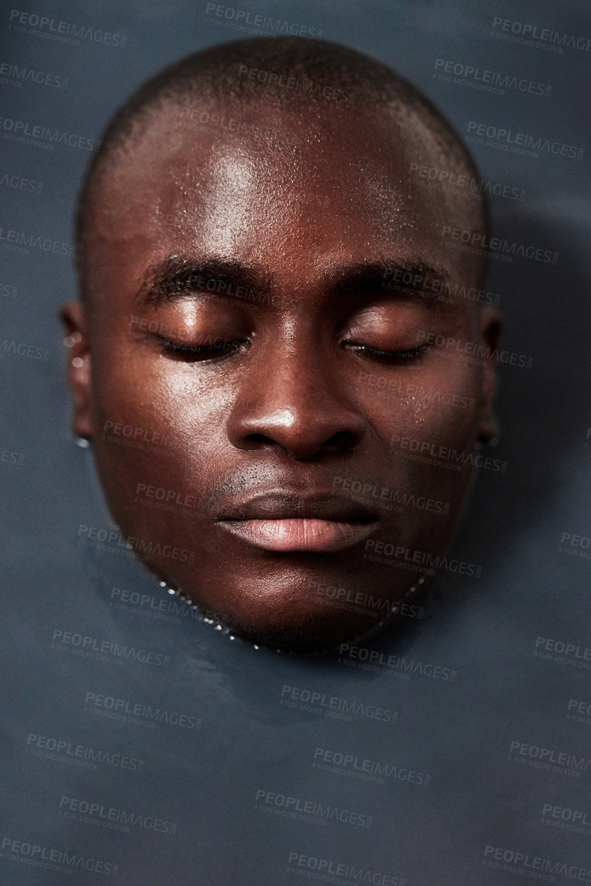 Buy stock photo Shot of a handsome young man submerged in a bath filled with dark water