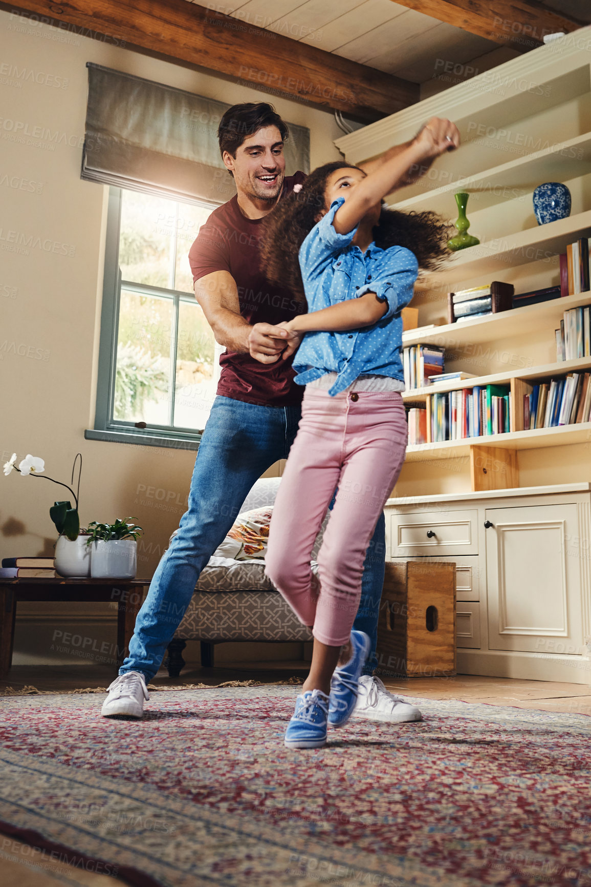 Buy stock photo Full length shot of a happy young father and daughter dancing together at home