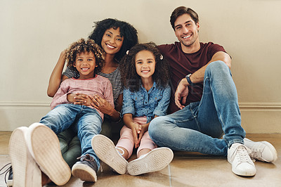 Buy stock photo Full length portrait of a beautiful young family of four sitting on the floor together at home