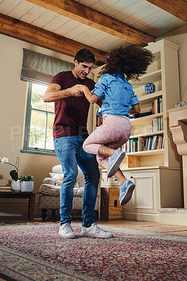 Buy stock photo Full length shot of a happy young father and daughter dancing together at home