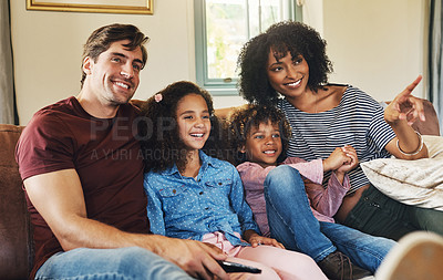 Buy stock photo Shot of a beautiful young family of four watching tv together at home