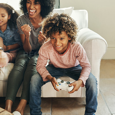 Buy stock photo Shot of an adorable little boy playing video games with his mom and sister at home
