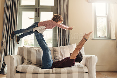Buy stock photo Full length shot of a father playing with his young son on a couch at home
