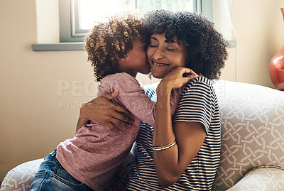 Buy stock photo Shot of an adorable little boy kissing his mother on the cheek while bonding together at home