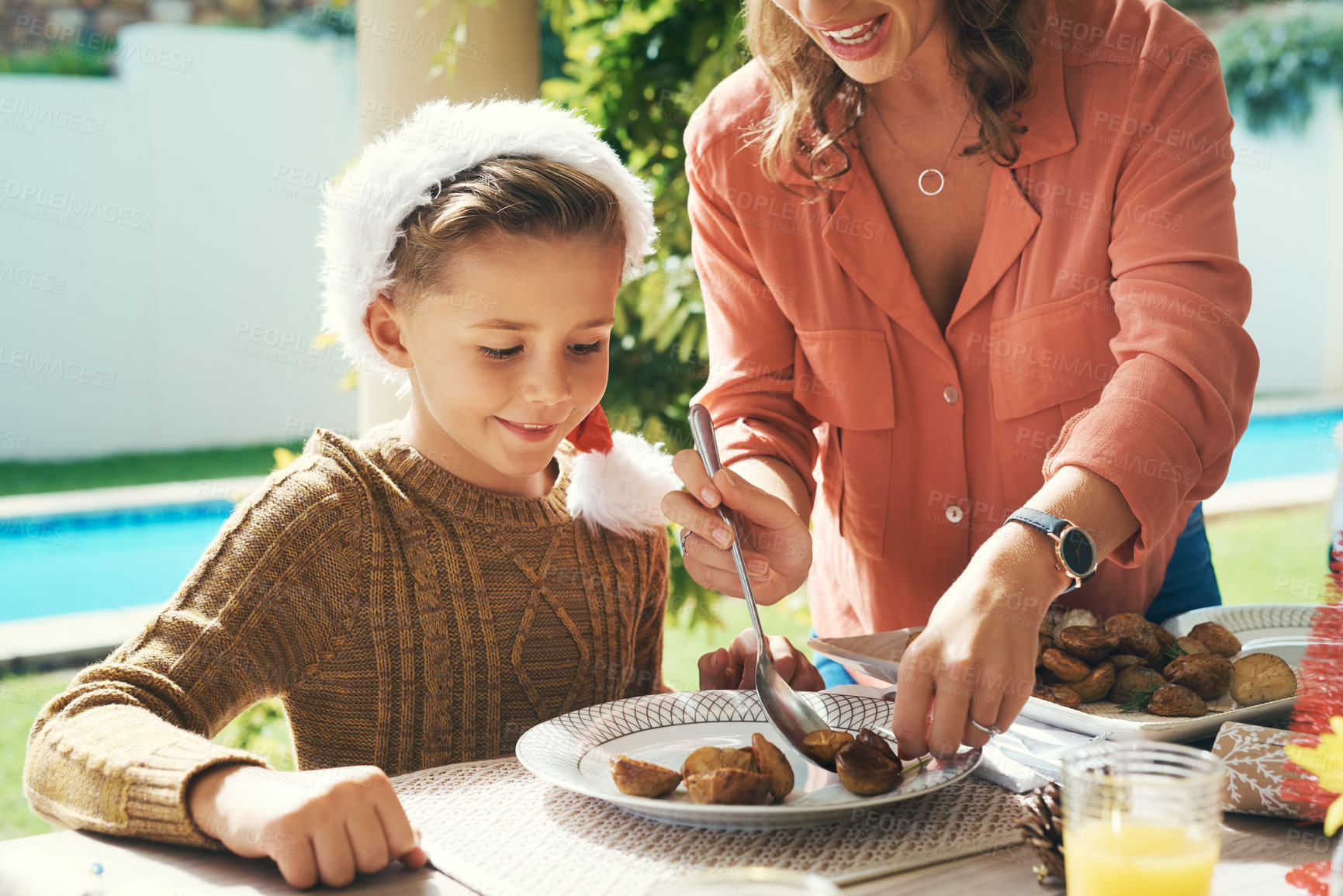 Buy stock photo Mother, food and helping child at table, Christmas lunch and parent care for son in backyard. Mommy, boy and dish plate with nutrition or healthy meal on traditional holiday, support and celebration