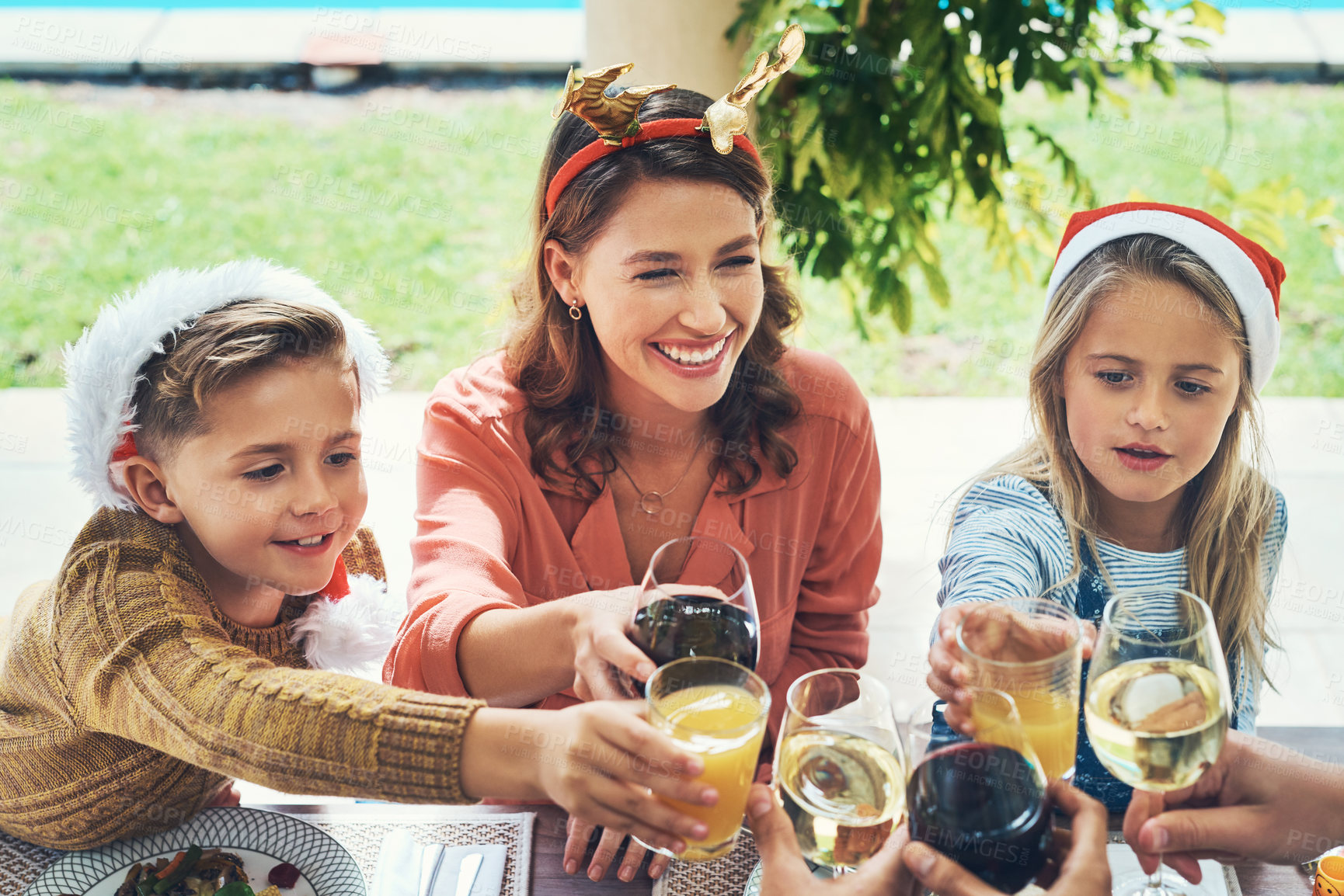 Buy stock photo Cheers, mom and kids at Christmas with glass, bonding and happy family celebration together for lunch. Toast, mother and children at table for festive holiday event with love, smile and fun at home