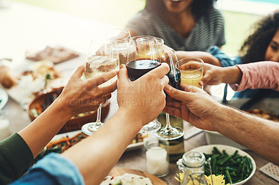 Buy stock photo Shot of a group of unrecognizable people joining their glasses together for a toast while enjoying a meal together outdoors