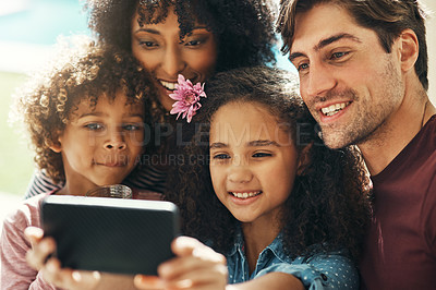 Buy stock photo Shot of a beautiful young family taking a selfie together outdoors